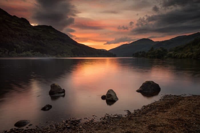 Three stones on quiet Loch Eck in sunset light, Scotland